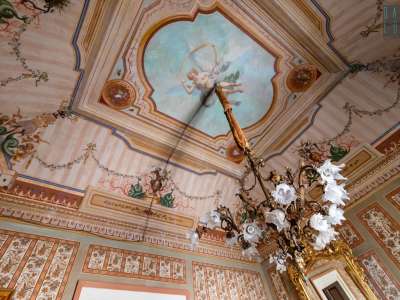 ...e una figura femminile su un cielo celeste. Dalla volata scende un raffinato candelabro in bronzo �vieux Paris�